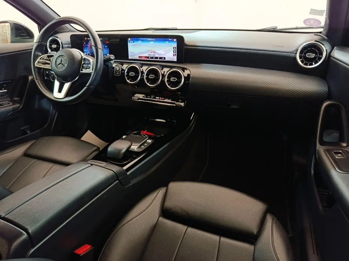 Intérieur noir de la Mercedes Classe A 200 Business Line 2021, vue de côté droit sur tableau de bord et console centrale.