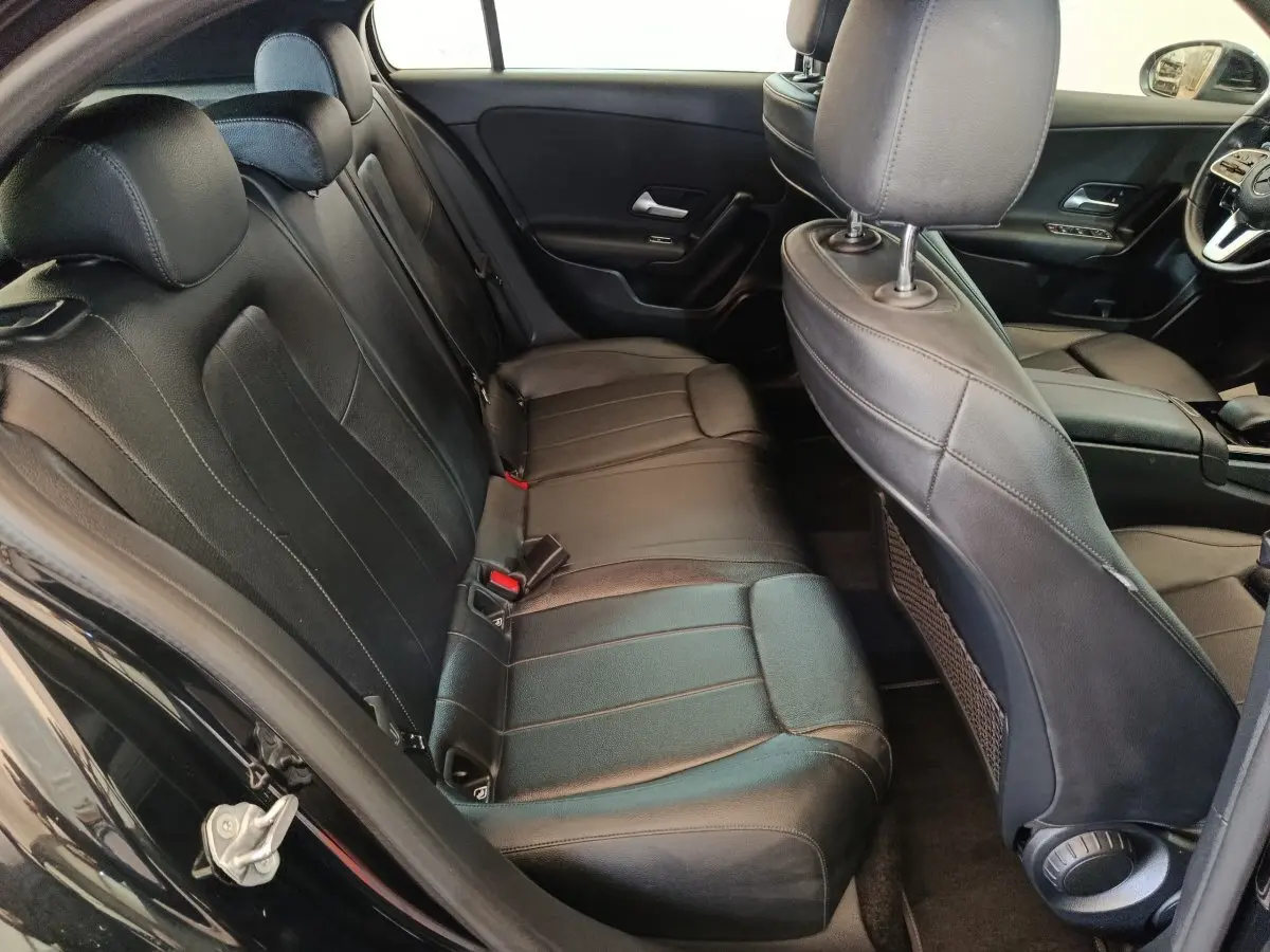 Vue intérieure côté gauche de la banquette arrière en cuir noir d'une Mercedes Classe A 200 Business Line 2021.