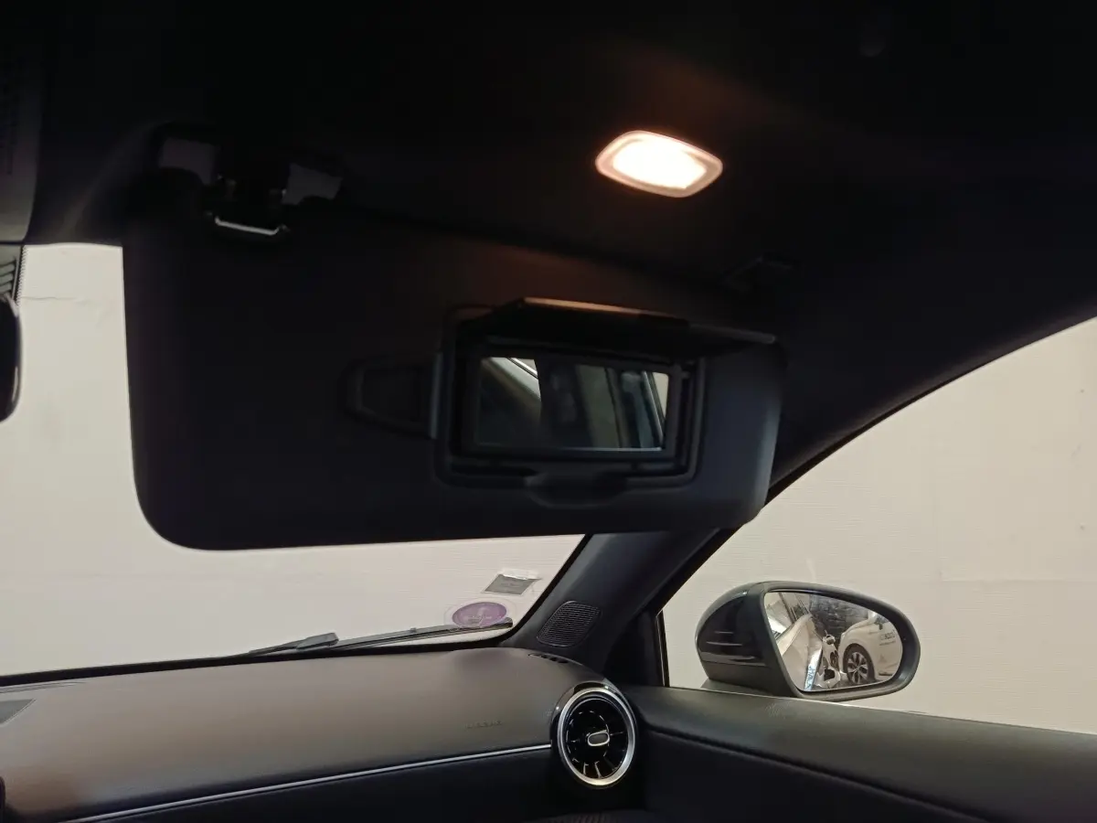 Intérieur noir de la Mercedes Classe A 200 Business Line 2021, vue côté droit avec pare-soleil et miroir éclairé.
