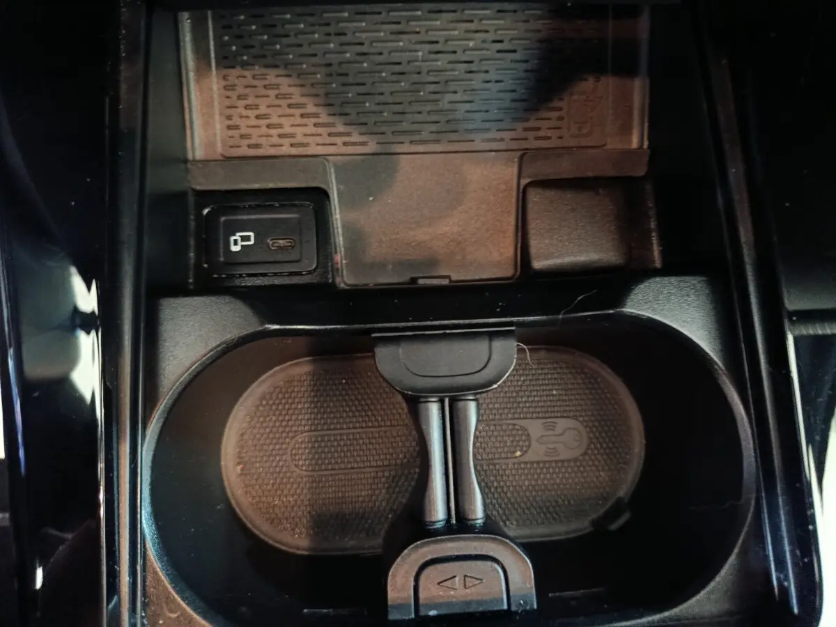 Vue plongeante sur la console centrale noire de la Mercedes Classe A 200 Business Line avec chargeur sans fil et port USB-C.
