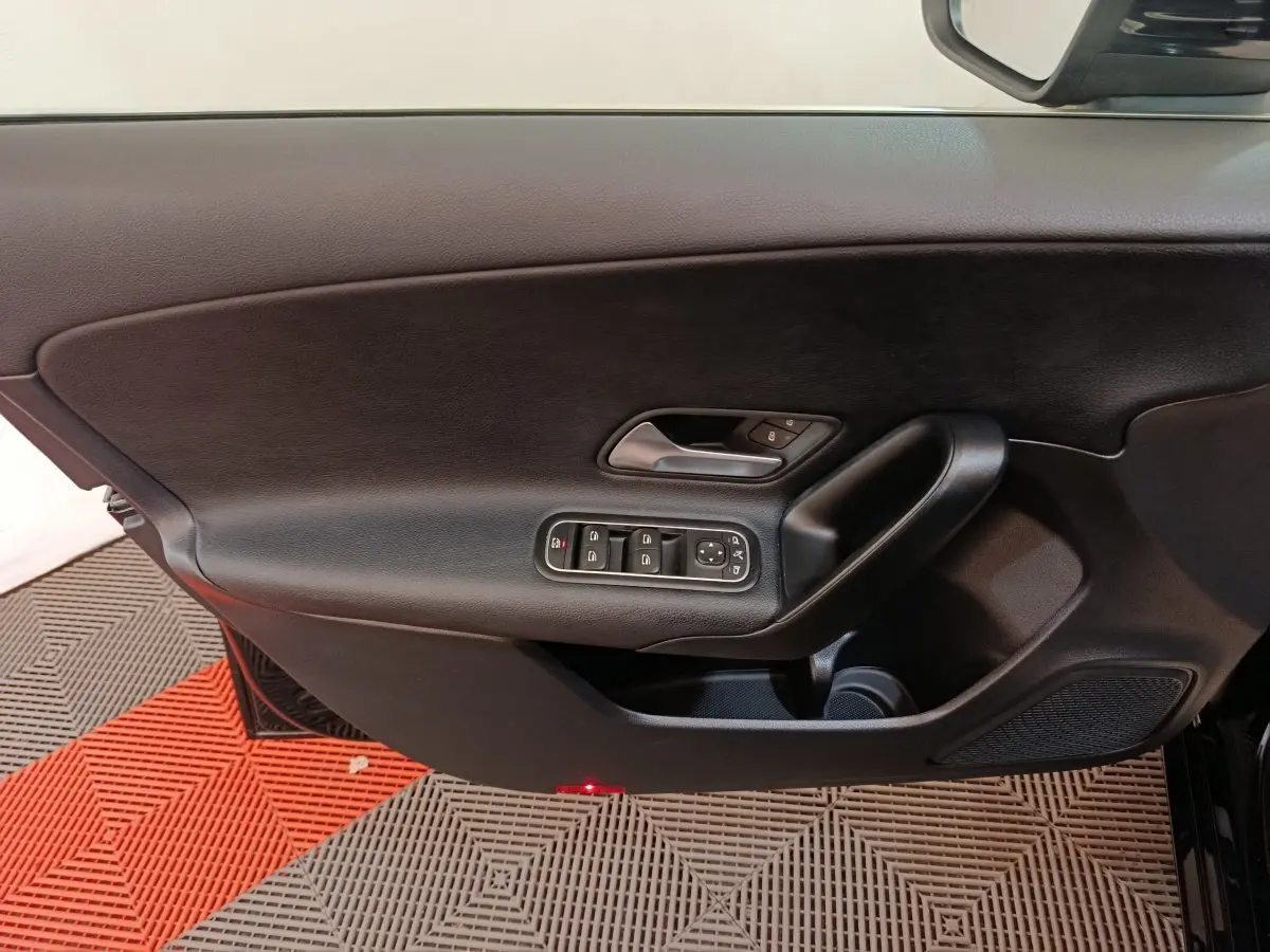 Vue rapprochée de la porte intérieure côté gauche noire de la Mercedes Classe A 200 Business Line avec commandes électriques.