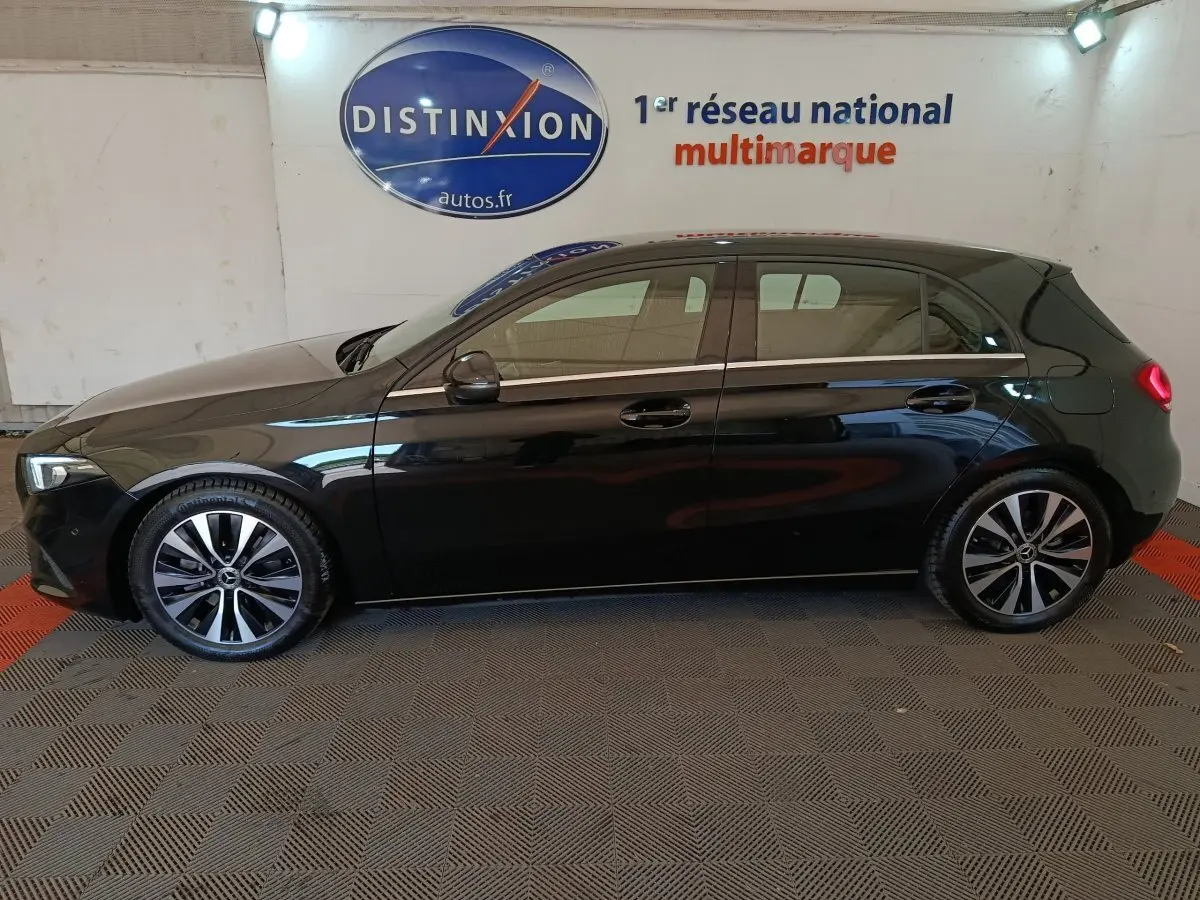 Vue de profil côté gauche d'une Mercedes Classe A A 200 Business Line noire, avec jantes alliage et feux arrière allumés.