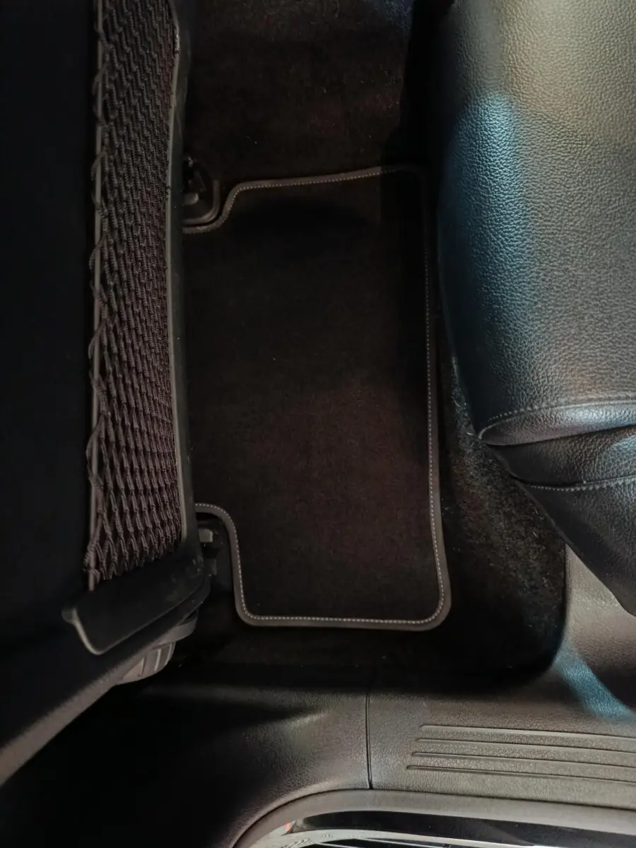 Détail du tapis de sol noir côté droit arrière avec partie de siège en cuir noir d’une Mercedes Classe A 200 Business Line 2021.