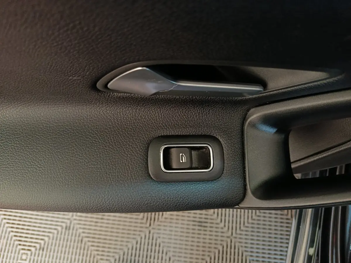 Détail de la poignée intérieure noire côté gauche avec bouton de verrouillage sur Mercedes Classe A A 200 Business Line 2021.
