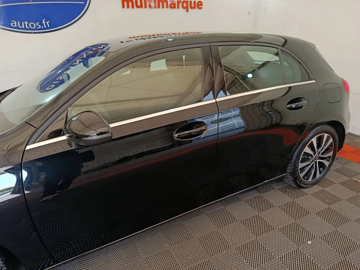 Vue latérale gauche d'une Mercedes Classe A 200 Business Line noire, avec jantes alliage et ligne chromée sur les portières.