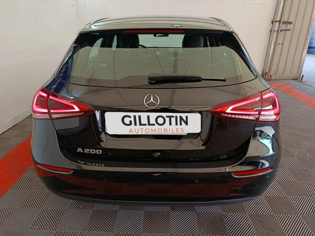 Vue arrière d'une Mercedes Classe A 200 Business Line noire avec feux LED allumés dans un garage.