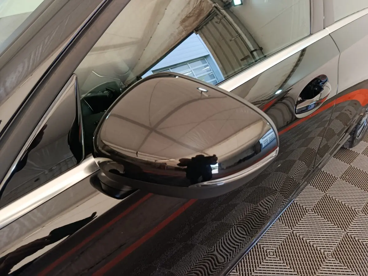 Gros plan sur le rétroviseur côté gauche d'une Mercedes Classe A 200 Business Line noire, reflet du plafond visible.