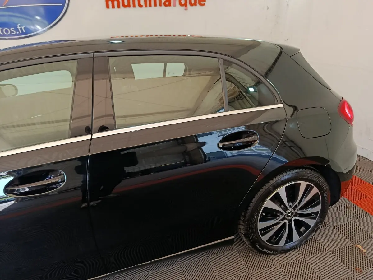 Vue latérale droite d'une Mercedes Classe A 200 Business Line noire, mettant en valeur les jantes alliage et le spoiler de toit.