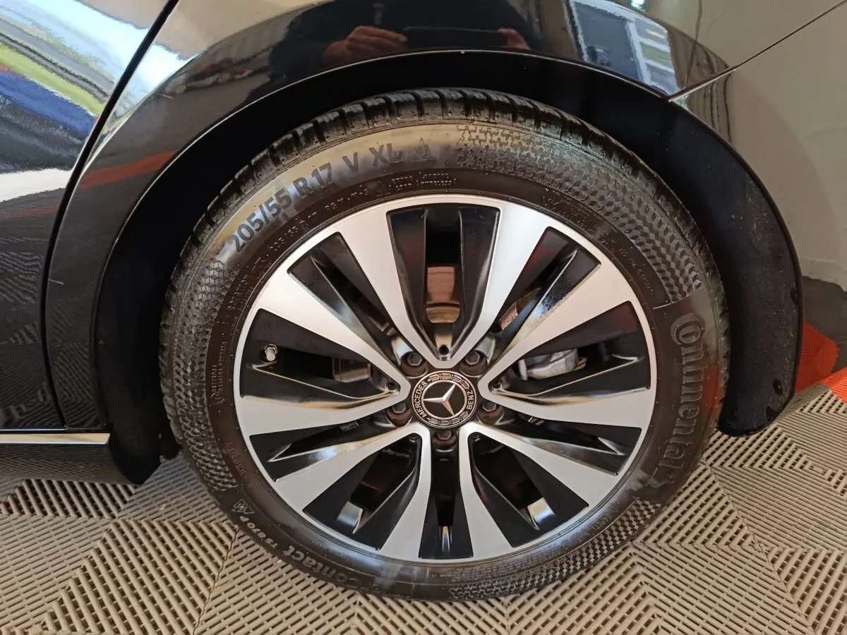Gros plan sur la roue avant gauche de la Mercedes Classe A noire, mettant en valeur la jante alliage bicolore et le pneu Continental.