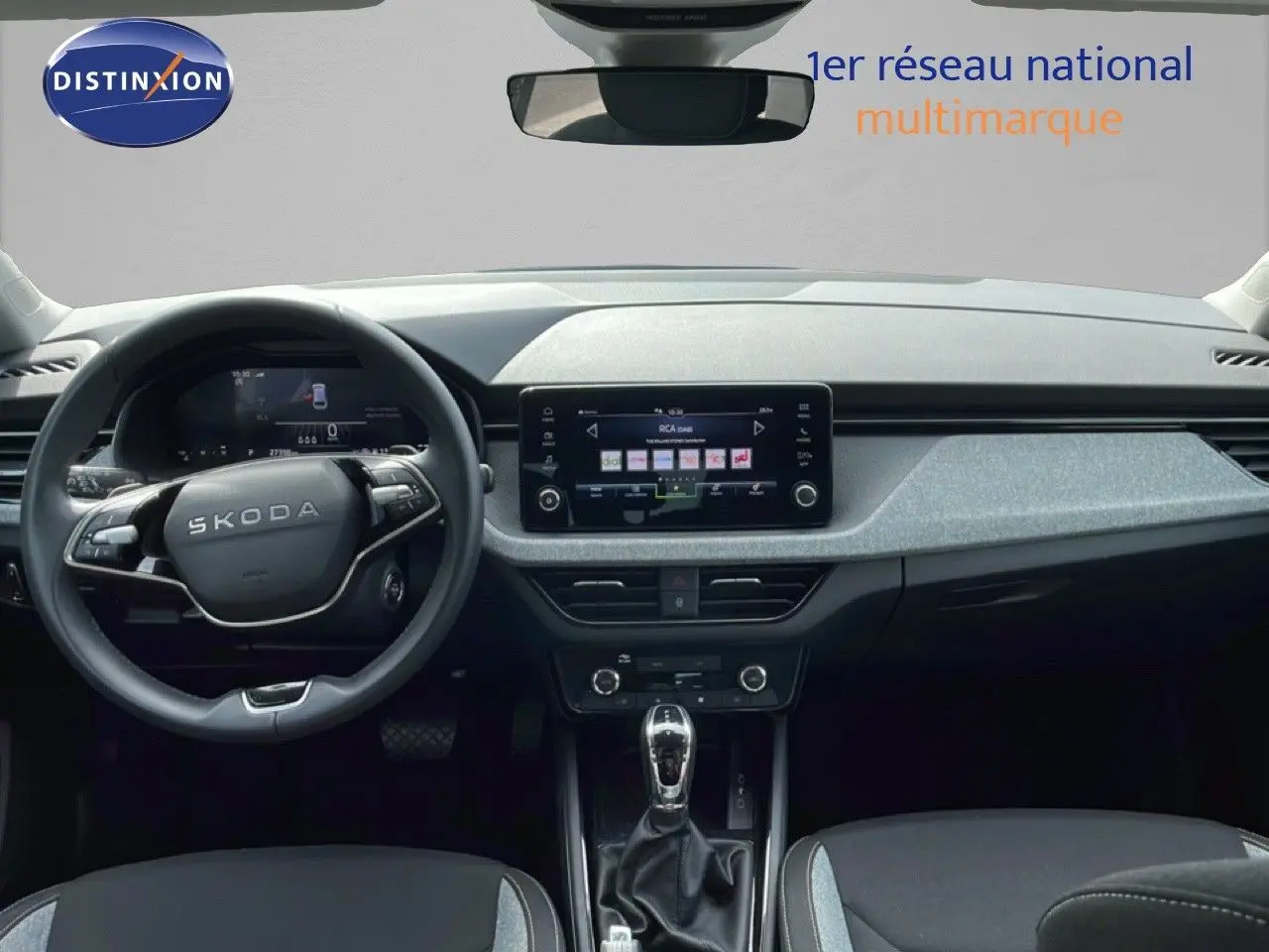 Vue intérieure avant du Skoda Scala 2025, tableau de bord moderne avec écran tactile central et volant multifonction noir.