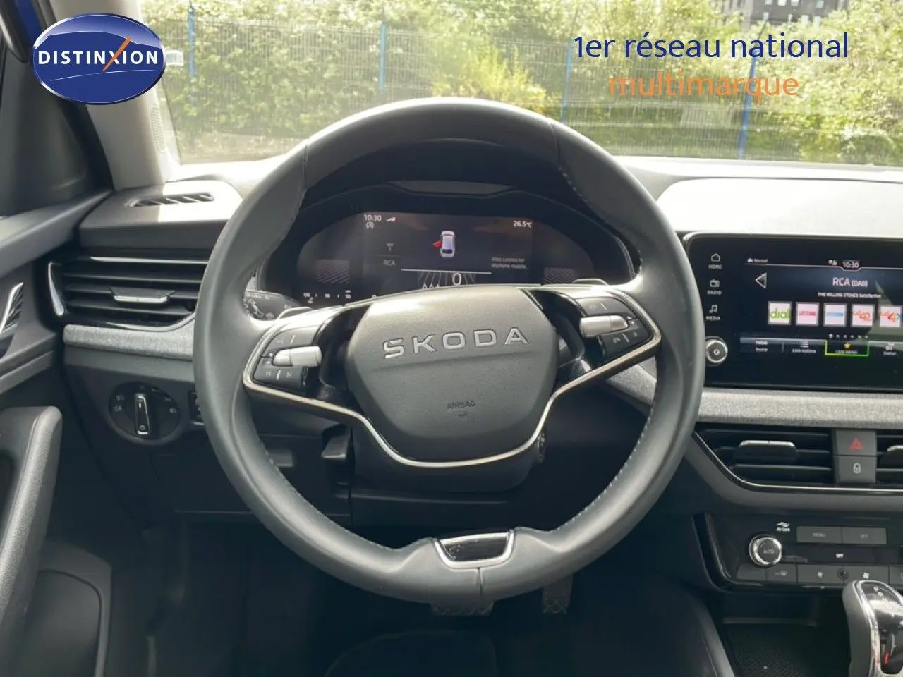 Vue intérieure centrée sur le volant SKODA de la Scala 2025, avec tableau de bord numérique et écran tactile multimédia.