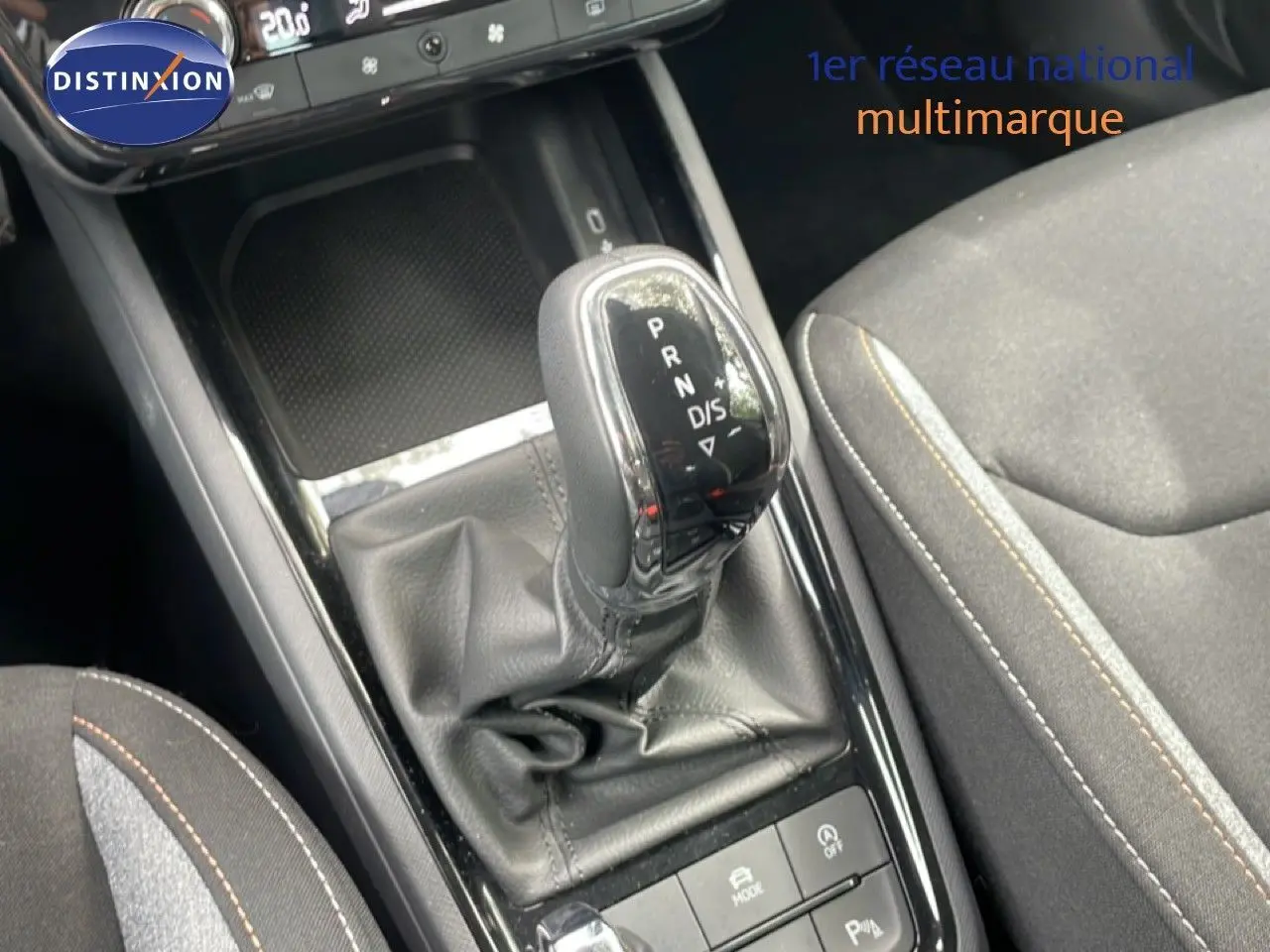 Gros plan sur la commande de boîte automatique et la console centrale du Skoda Scala 2025 en tissu gris avec surpiqûres contrastées.