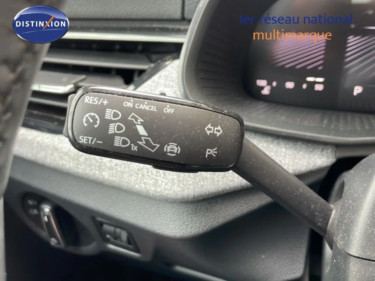 Gros plan sur la commande de régulateur de vitesse dans l’habitacle d’une Skoda Scala bleu Racing Metal.