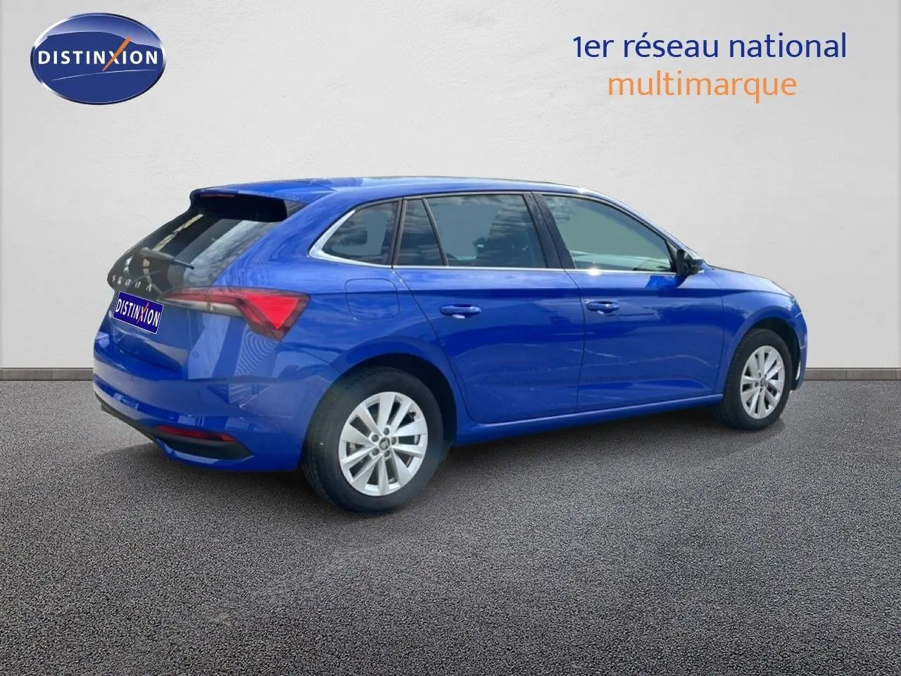 Vue 3/4 arrière droite d'une Skoda Scala bleu racing metal avec jantes alliage et vitres teintées.