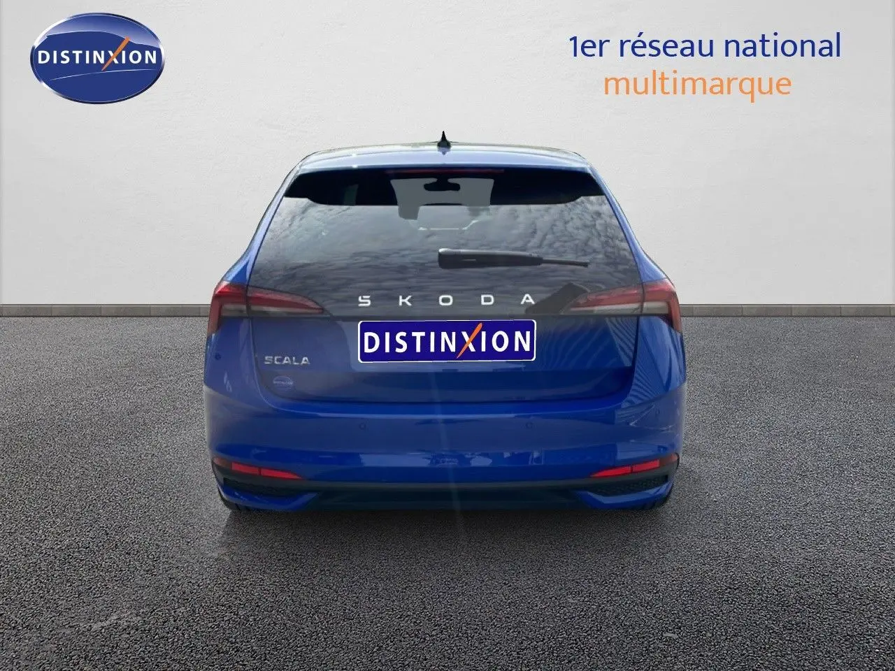 Vue arrière d'une Skoda Scala bleu racing metal 2025, avec feux arrière étirés et logo distinctif au centre.