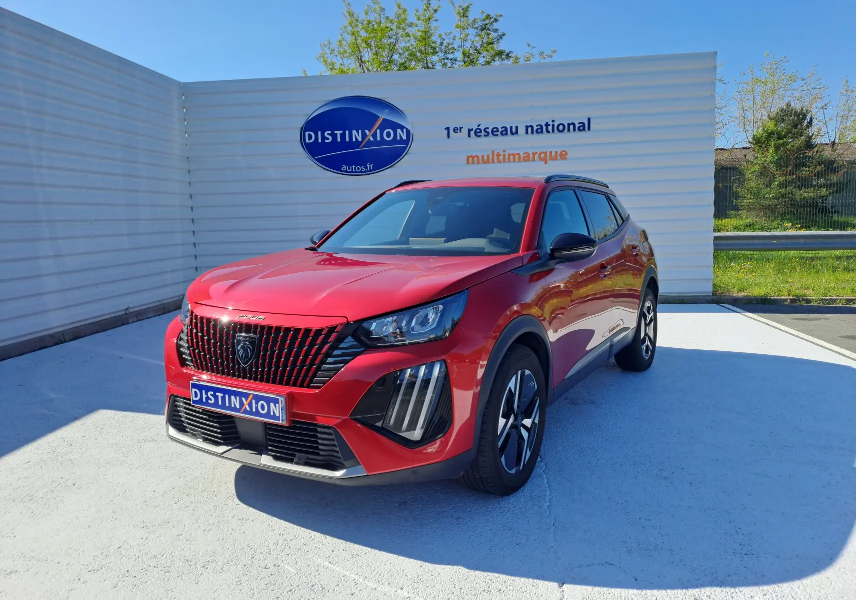 Peugeot 2008 rouge Elixir vue en 3/4 avant droit, avec calandre noire distinctive et jantes alliage bicolores.