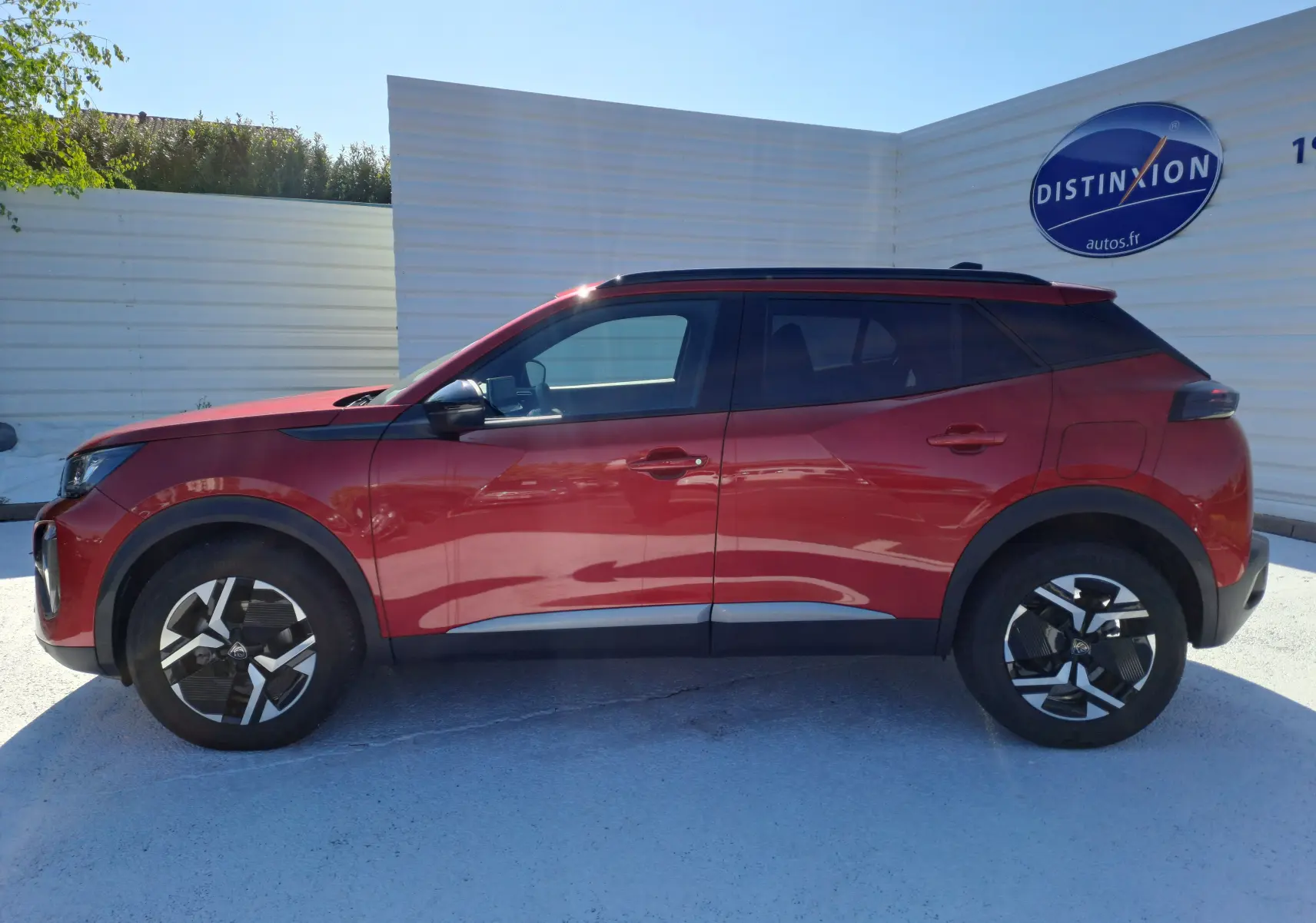 Profil côté gauche d'un Peugeot 2008 1.2 PureTech 100 Allure rouge Elixir avec jantes alliage noires et grises.
