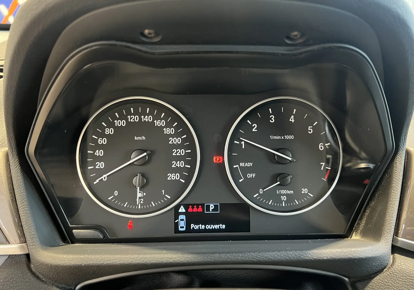 Vue rapprochée du tableau de bord noir du BMW X1 F48 2017 avec compte-tours, compteur de vitesse et affichage digital.