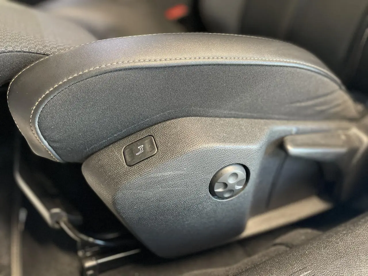 Gros plan sur les commandes latérales du siège avant en cuir noir de la Peugeot 508 SW 2021.