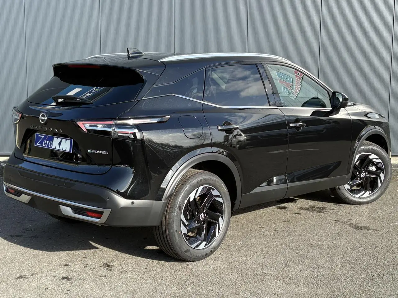 Vue 3/4 arrière droite du Nissan Qashqai III e-Power noir avec jantes alliage noires et toit contrasté gris.