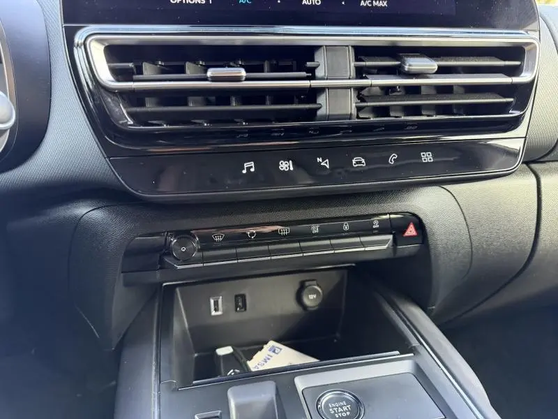 Vue rapprochée de la console centrale du Citroën C5 Aircross 2024 gris, montrant les commandes de climatisation et prise USB.