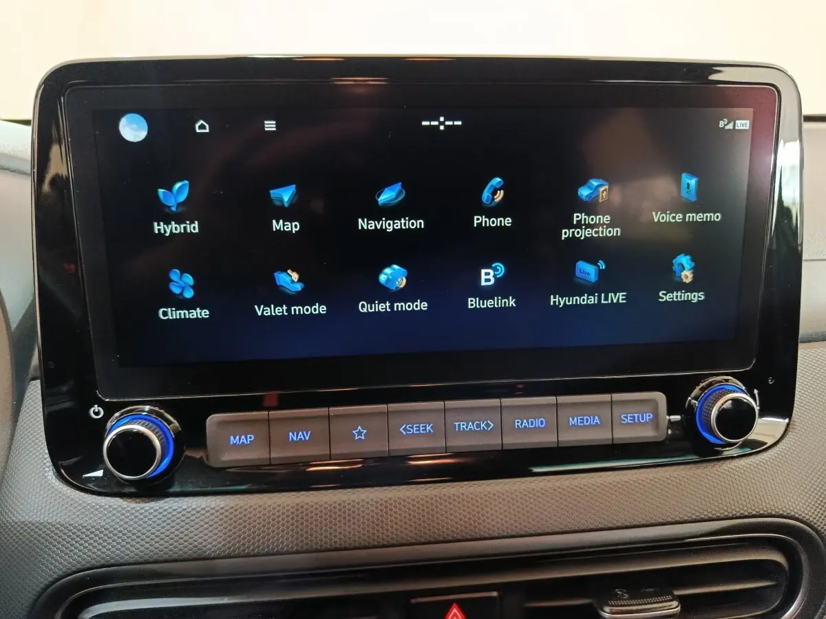 Écran tactile central du tableau de bord du Hyundai Kona 1.6 Hybrid 2023, affichant les options de navigation et connectivité.