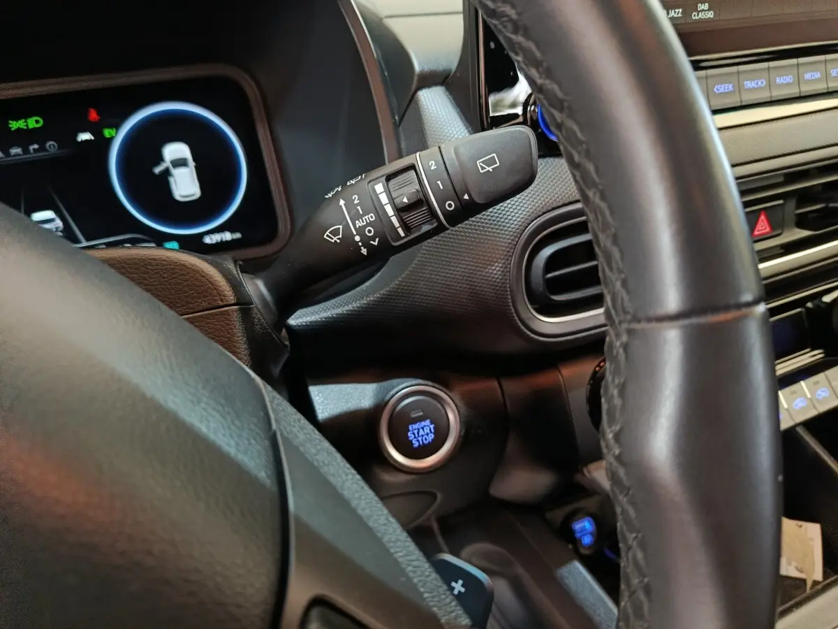 Vue intérieure rapprochée du volant cuir noir et du bouton démarrage du Hyundai Kona 1.6 Hybrid 2023.