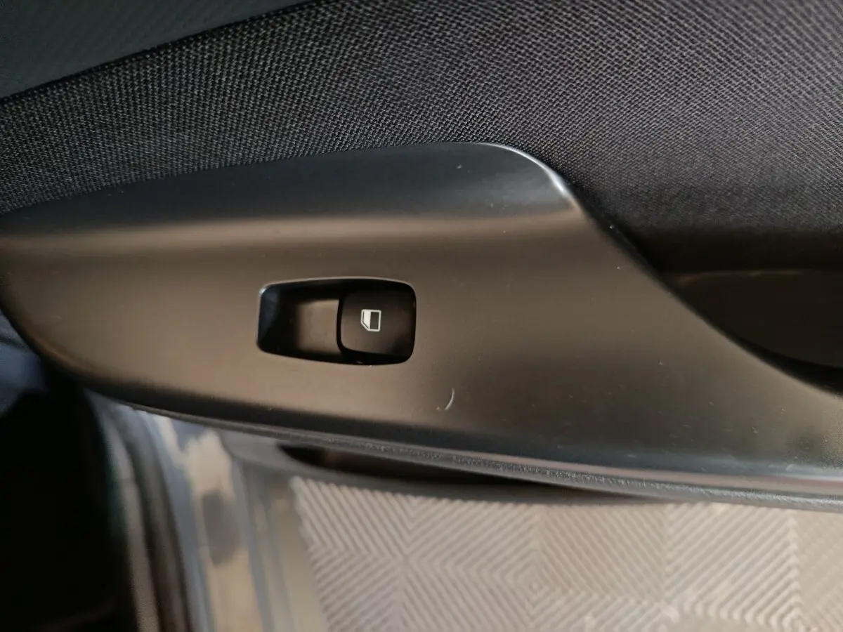 Bouton de commande de vitre électrique sur la porte intérieure côté conducteur d’un Hyundai Kona gris foncé.