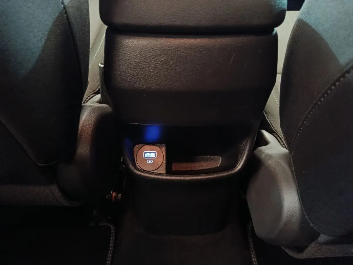 Vue rapprochée de la prise USB arrière entre les sièges avant du Hyundai Kona gris foncé 2023.