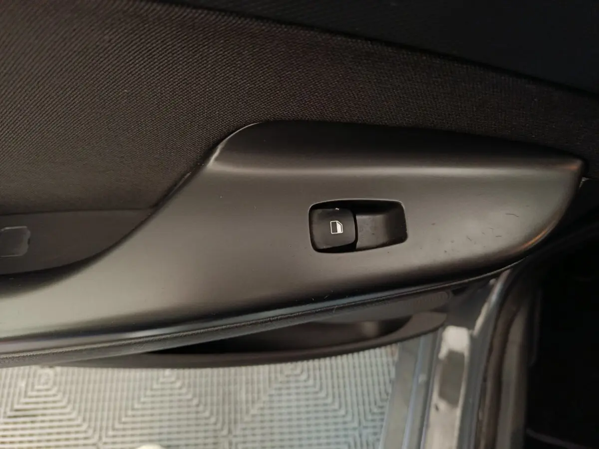 Gros plan sur le bouton de verrouillage des portes côté gauche d'une Hyundai Kona gris foncé, version hybride 2023.