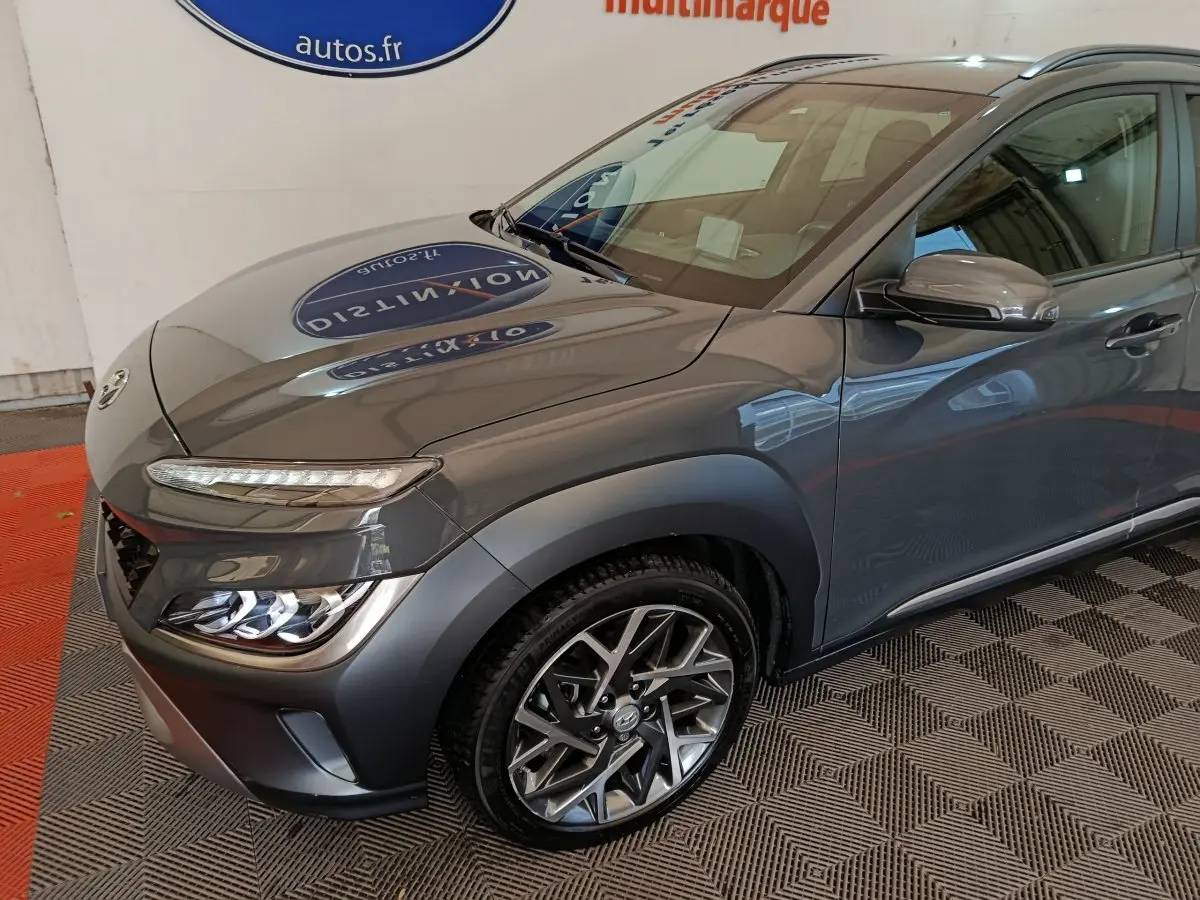 Vue 3/4 avant droit d'un Hyundai Kona gris foncé mettant en valeur ses phares LED et ses jantes alliage au design moderne.