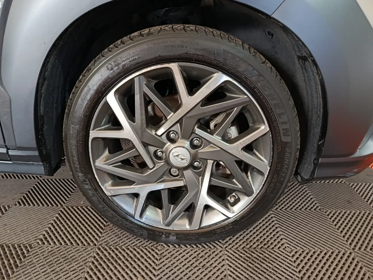 Gros plan sur la jante alliage grise au design géométrique du côté arrière droit d’un Hyundai Kona gris foncé.