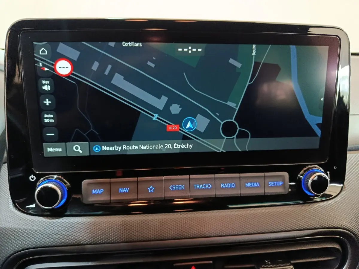 Écran tactile central du tableau de bord du Hyundai Kona gris foncé, affichant la navigation GPS en vue rapprochée.