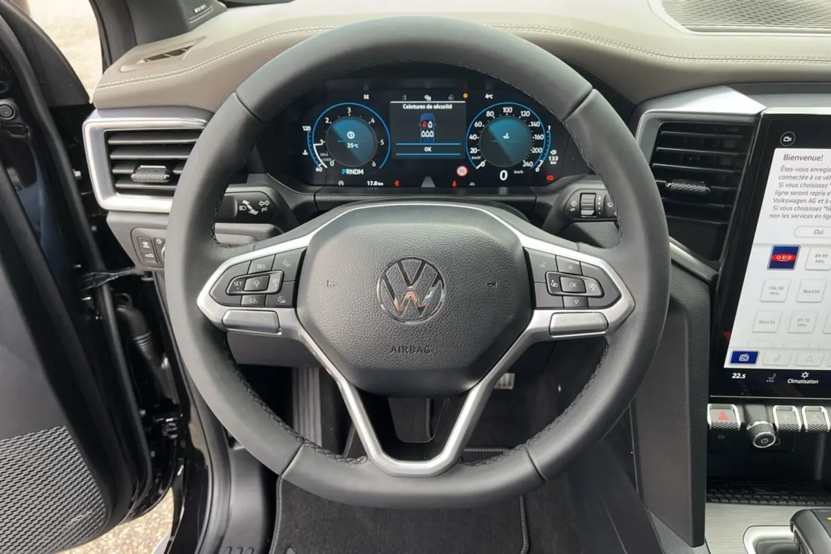 Vue rapprochée du volant cuir multifonctions et tableau de bord digital du Volkswagen Amarok noir 2025, version V6 Aventura.