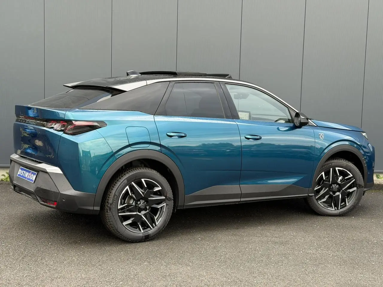 Vue latérale droite d’un Peugeot 3008 Hybrid 145 GT bleu Obsession avec toit noir et jantes alliage 19 pouces.
