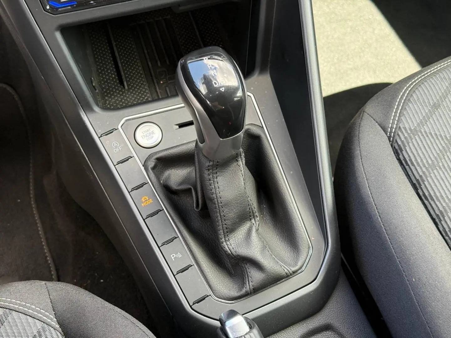 Gros plan sur le levier de vitesses automatique noir et cuir dans l'habitacle gris du Volkswagen Taigo 2025.
