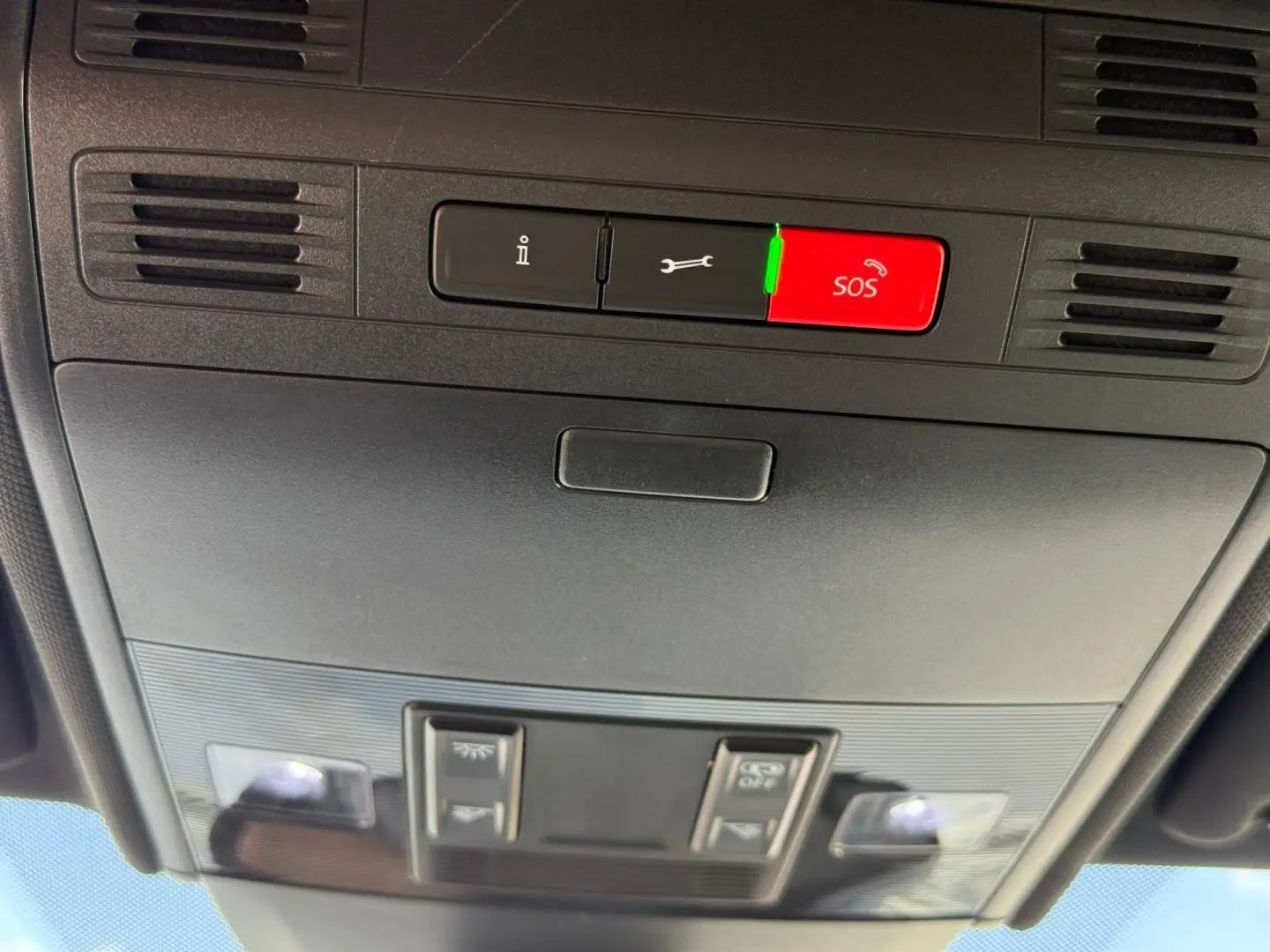 Vue en contre-plongée du plafonnier gris avec bouton SOS rouge et commandes d’éclairage dans un Volkswagen Taigo 2025.