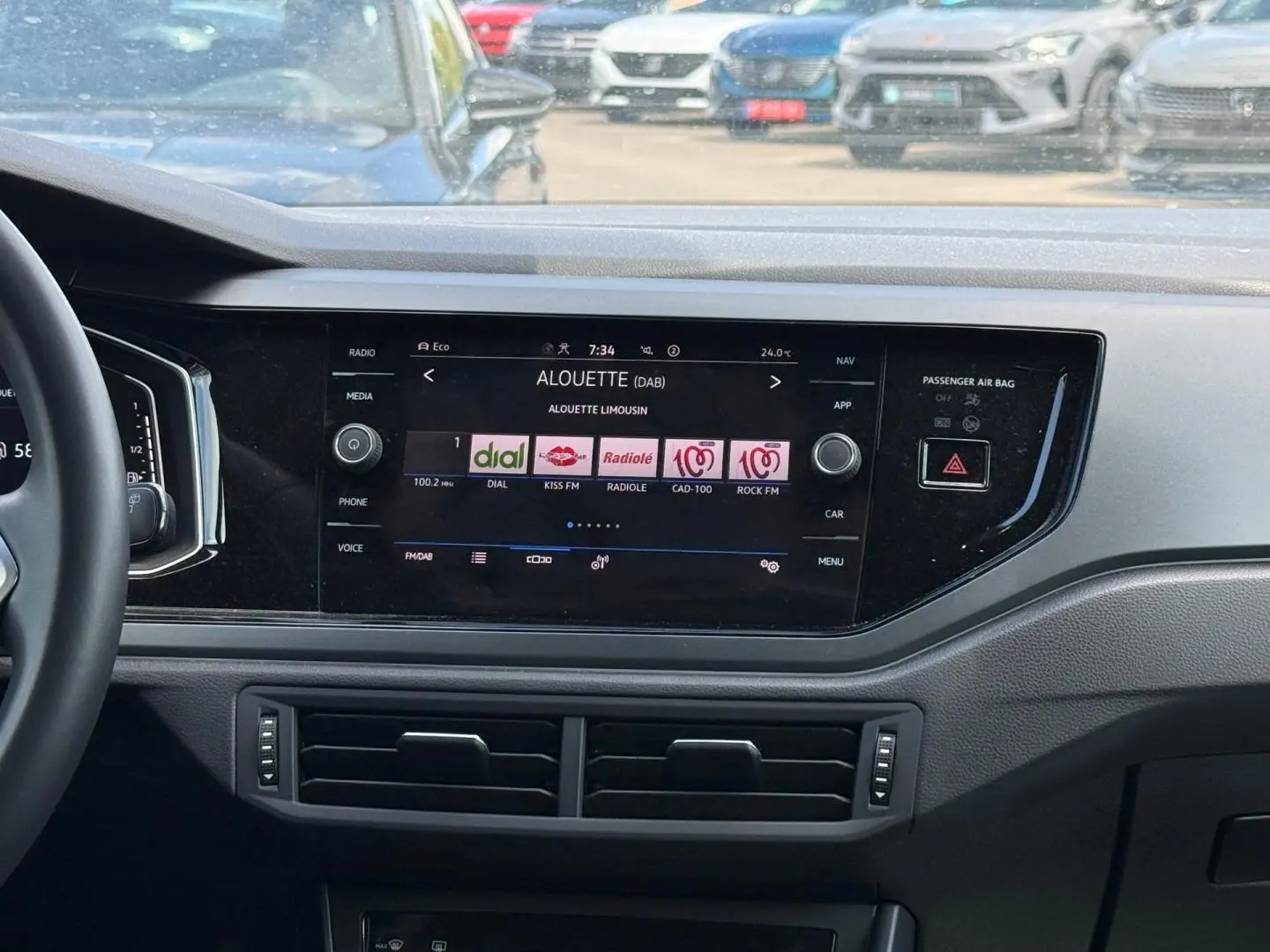Tableau de bord du Volkswagen Taigo 2025 avec écran tactile central affichant des stations radio, volant partiel à gauche visible.