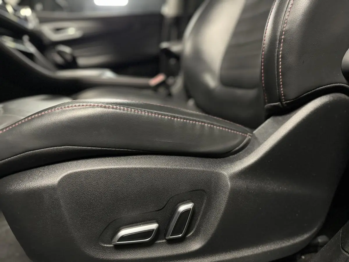 Gros plan sur le siège avant conducteur en cuir noir avec surpiqûres rouges du MG Motor EHS 2022.