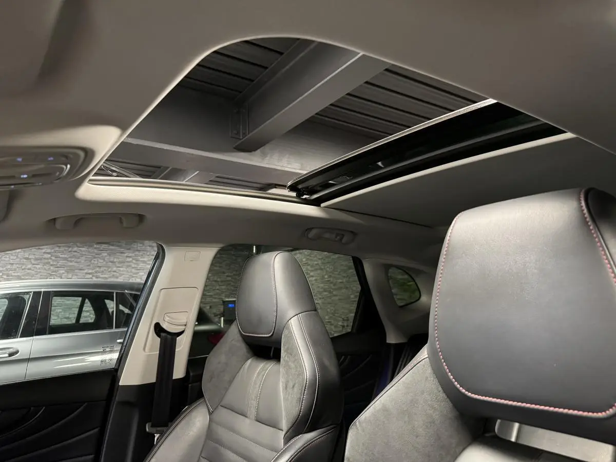 Vue intérieure du toit ouvrant panoramique et sièges avant cuir noir avec surpiqûres rouges du MG MOTOR EHS noir 2022.