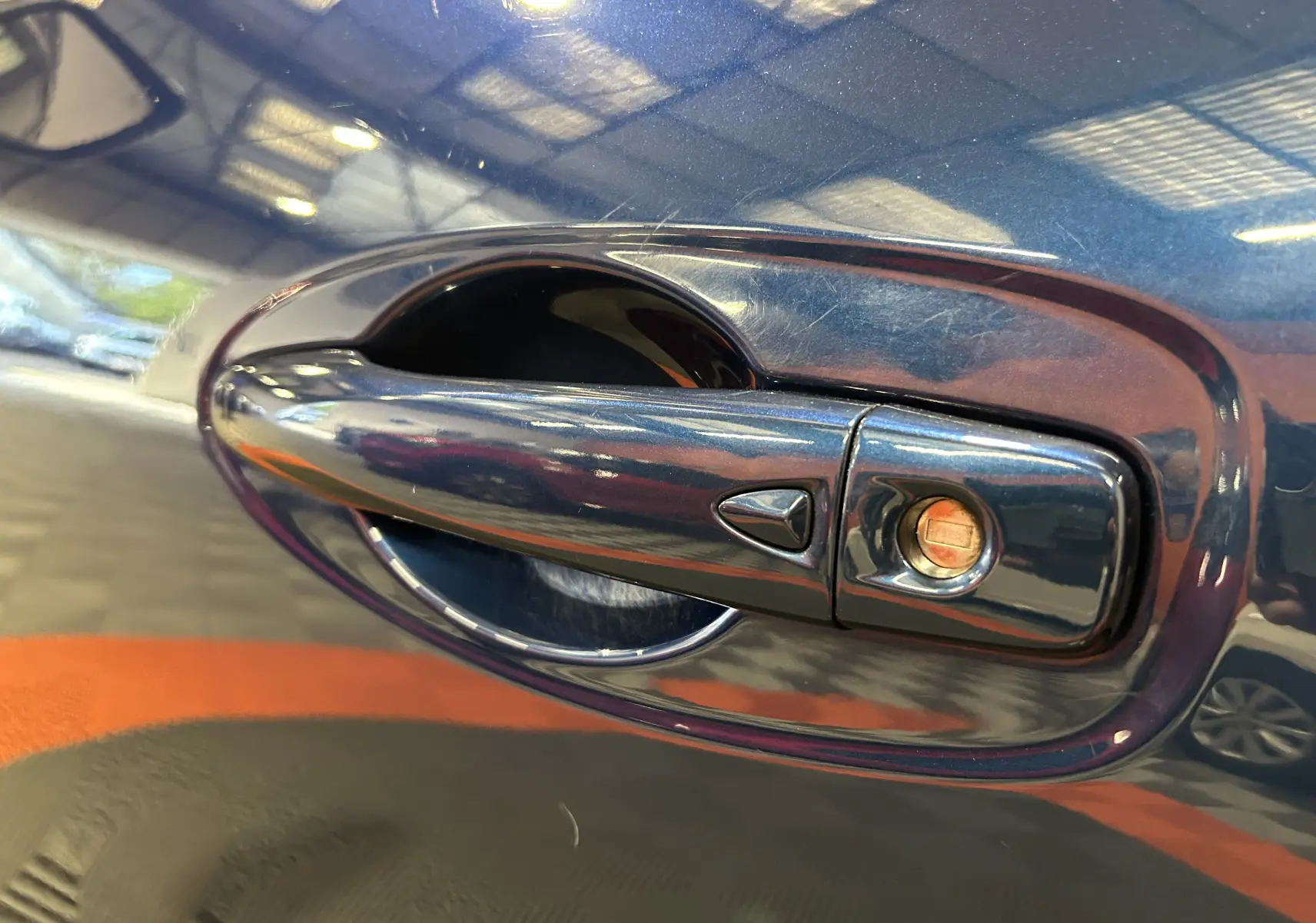 Poignée de porte avant droite bleu métallisé d'un Renault Kadjar TCe 130 EDC energy Intens 2017 avec serrure visible.