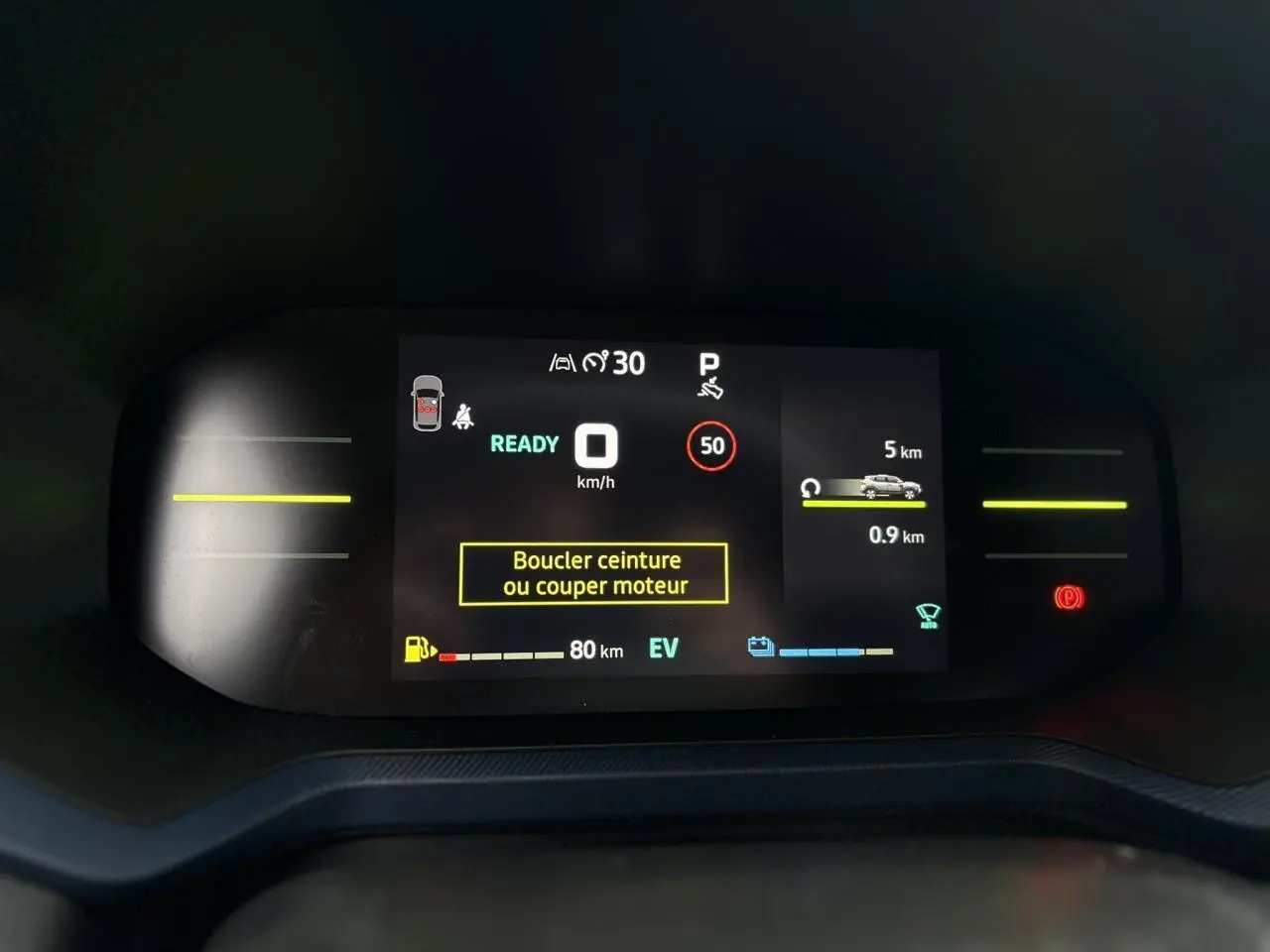 Tableau de bord digital du Dacia Duster 2025 affichant vitesse, autonomie et alertes de sécurité en mode hybride.