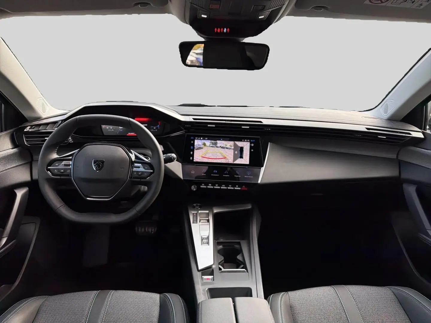 Vue avant de l’habitacle du Peugeot 408 Hybrid 145 allure 2025, volant cuir et écran tactile affichant la caméra de recul.