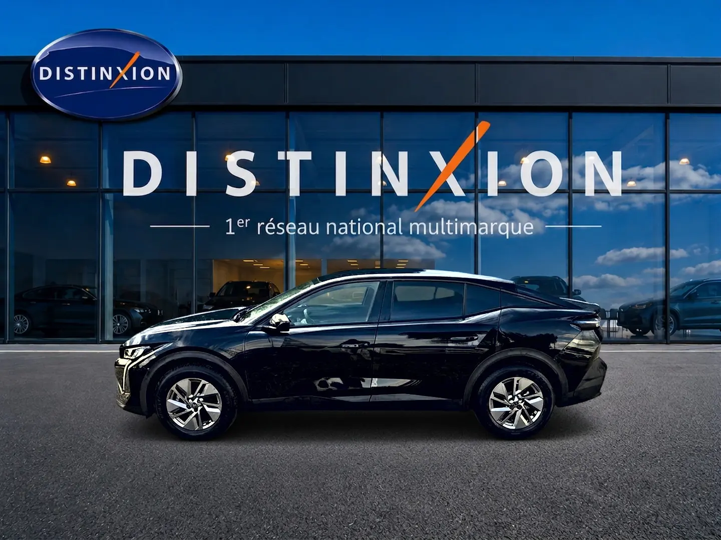 Profil côté gauche d'une Peugeot 408 Hybrid 145 allure e-dcs6 noire, garée devant une vitrine Distinxion.