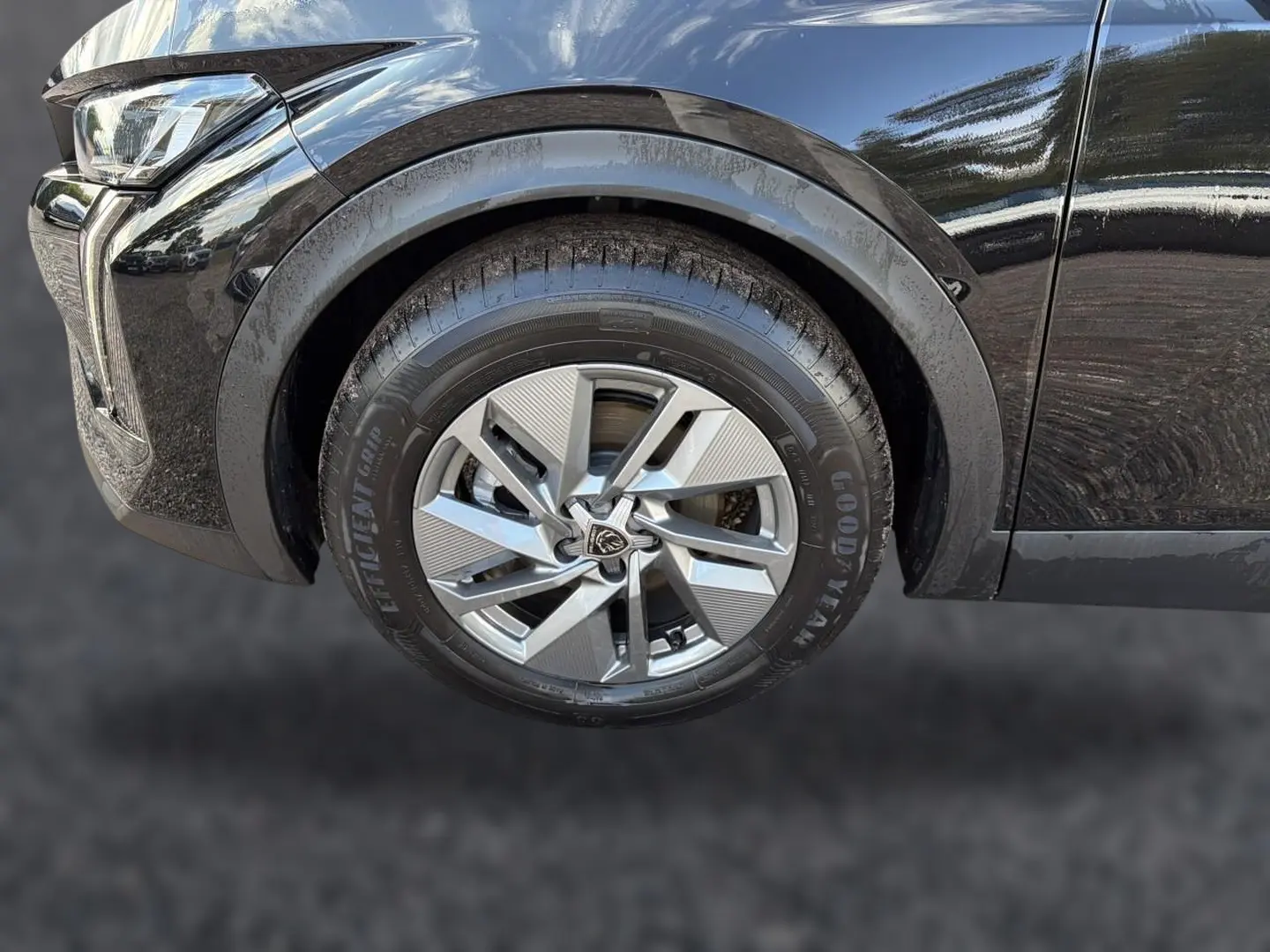 Gros plan sur la roue avant gauche alu d’un Peugeot 408 noir, avec partie avant et passage de roue visibles.