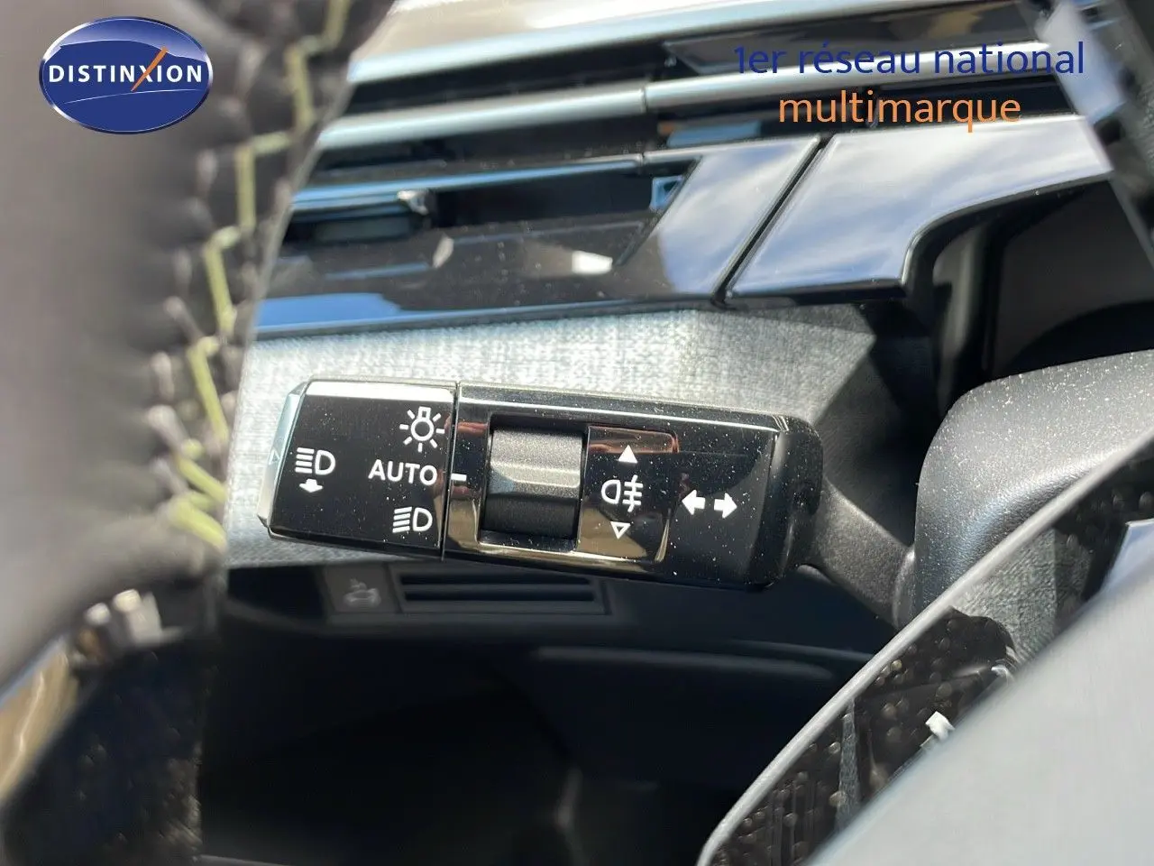 Gros plan sur la commande des phares et clignotants du Peugeot 3008 hybride 2025, intérieur noir et détails chromés.