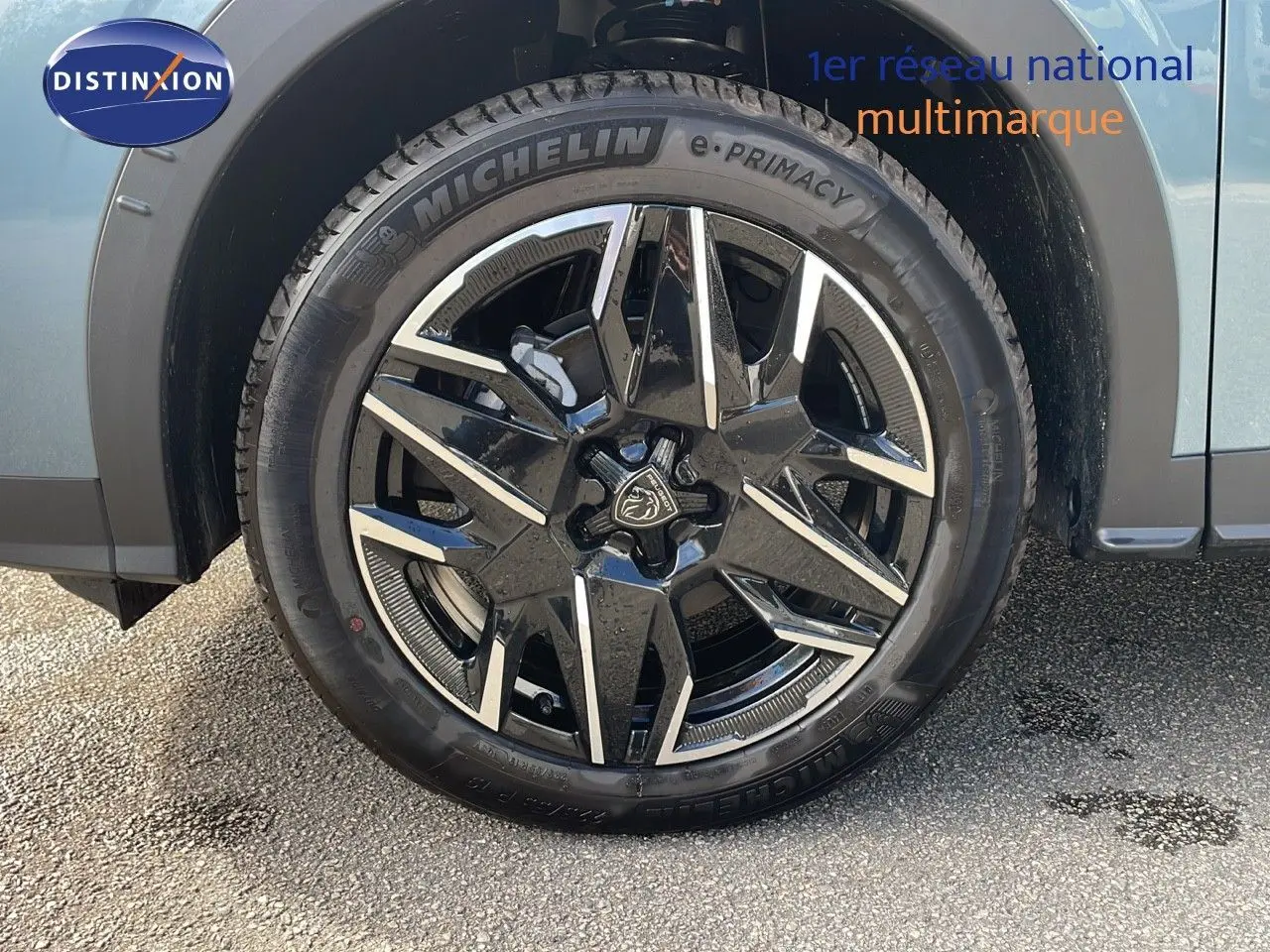 Gros plan sur la jante noire et argentée du côté avant gauche d'un Peugeot 3008 bleu Ingaro métal.