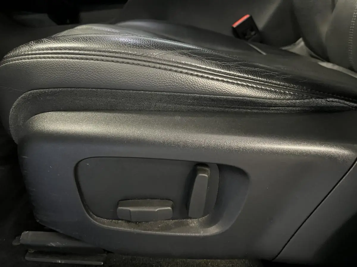 Gros plan sur les commandes électriques du siège avant en cuir noir du Range Rover Evoque blanc de 2020.