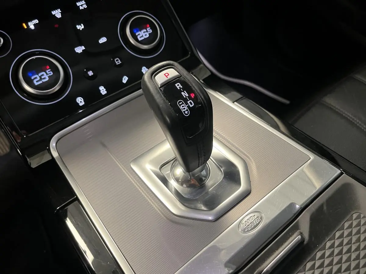 Le levier de vitesses automatique noir et argenté du Range Rover Evoque 2020, avec commandes de climatisation en arrière-plan.