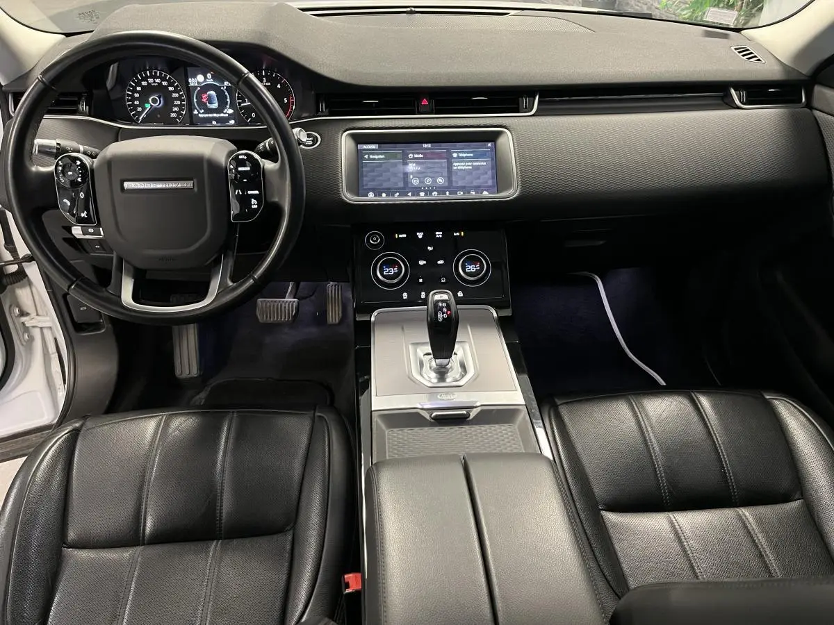 Intérieur noir du Range Rover Evoque 2020 vu de face, avec tableau de bord digital et console centrale moderne.